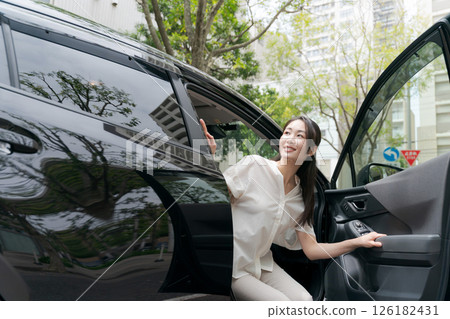 一位年輕的女士從車上下來 一位年輕的女士從車上下來 126182431