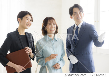 Smiling man and woman in business suits holding files 126182445