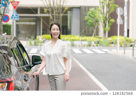 Female driver standing next to a car Female driver standing next to a car 126182568