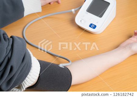 A woman measuring blood pressure A woman measuring blood pressure 126182742