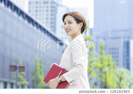Business: Portrait of a woman walking through an office district 126182983