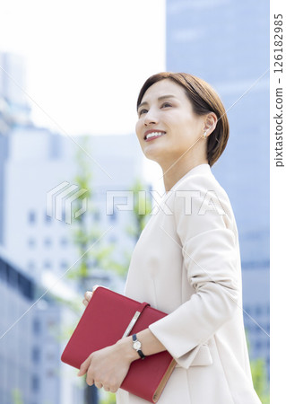 Business: Portrait of a woman walking through an office district 126182985