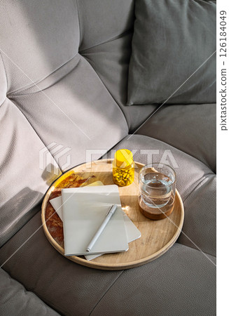 Bottle of Pills, Glass of Water and Notebook on Tray on Couch. Daily Routine, Personal Health Care Planning at Home. 126184049