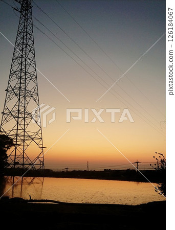 A steel tower and a rural landscape in the sunset 126184067