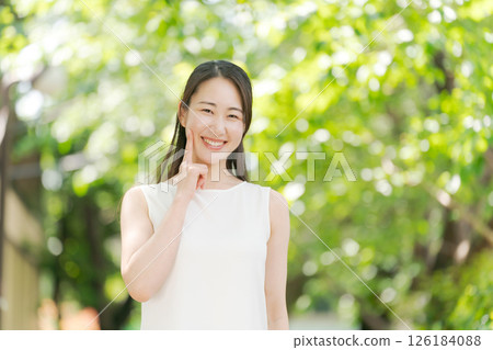 Portrait of a woman in her twenties standing in a summer park 126184088