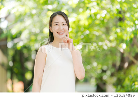 Portrait of a woman in her twenties standing in a summer park 126184089