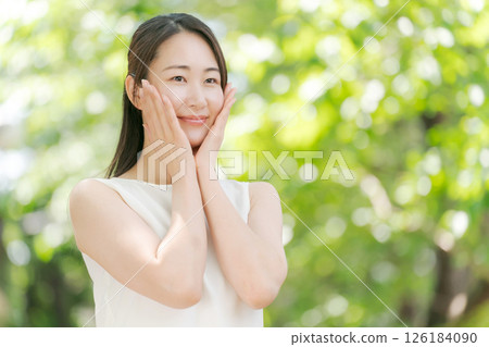 Portrait of a woman in her twenties standing in a summer park 126184090