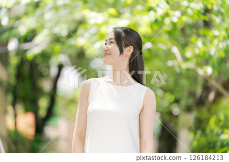 Portrait of a woman in her twenties standing in a summer park 126184213