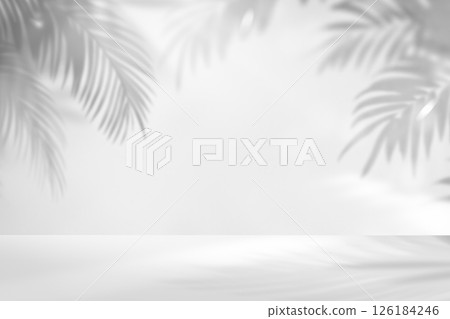 A white background with a hazy shadow and light reflections from palm leaves 126184246