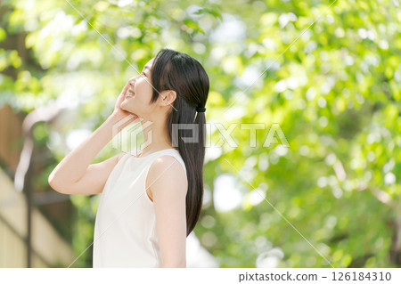 Portrait of a woman in her twenties standing in a summer park Portrait of a woman in her twenties standing in a summer park 126184310