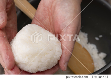 The process of applying salt to hands and making rice balls The process of applying salt to hands and making rice balls 126184481