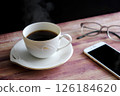 Steaming hot coffee, smartphone and glasses 126184620