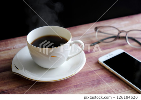 Steaming hot coffee, smartphone and glasses Steaming hot coffee, smartphone and glasses 126184620