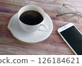 Smartphone and coffee and glasses on a wooden table 126184621