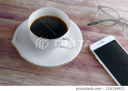 Smartphone and coffee and glasses on a wooden table Smartphone and coffee and glasses on a wooden table 126184621