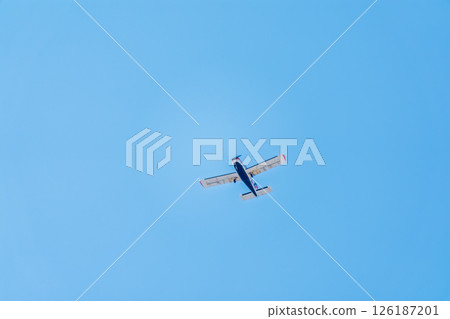 Small ultralight airplane with overhead wing and single propeller flying in sunset sky. Small ultralight airplane with overhead wing and single propeller flying in sunset sky. 126187201