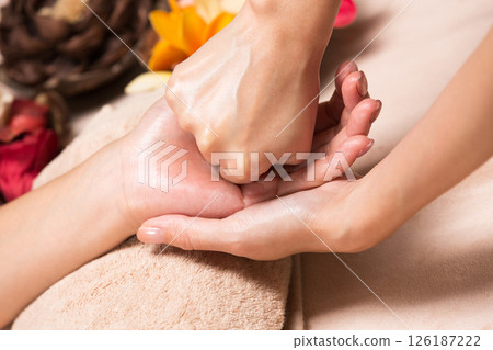 一位年輕的亞洲女性正在接受手部按摩。	 一位年輕的亞洲女性正在接受手部按摩。	 126187222