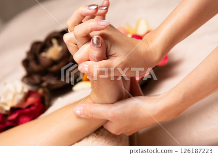 A young Asian woman is getting a hand massage. 126187223