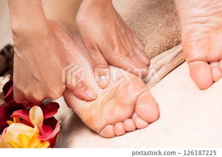 A young Asian woman is getting a foot massage. A young Asian woman is getting a foot massage. 126187225