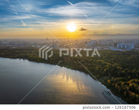 Autumn forest on lake shore at sunset and city on horizon, auerial view Autumn forest on lake shore at sunset and city on horizon, auerial view 126187306