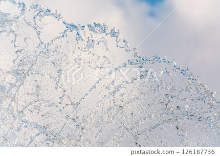 Splashes and jets of water against light background. Splashes and jets of water against light background. 126187736