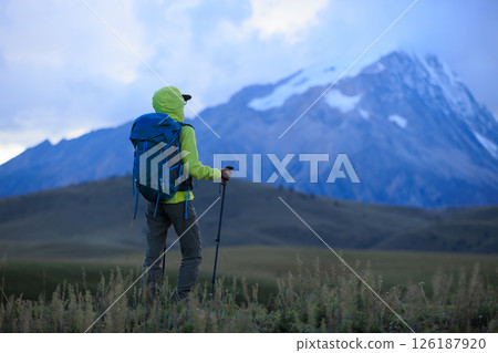 Woman backpacker hiking on high altitude mountains Woman backpacker hiking on high altitude mountains 126187920