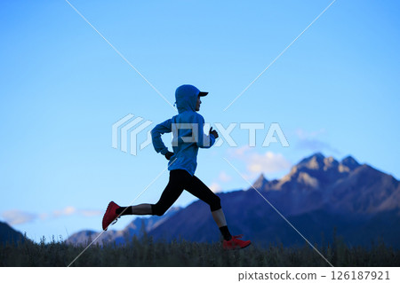 Fitness woman trail runner running on grassland mountain top 126187921