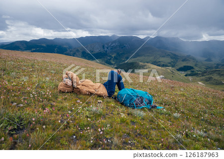 Woman hiker enjoy lying on the high altitude mountain top grass 126187963