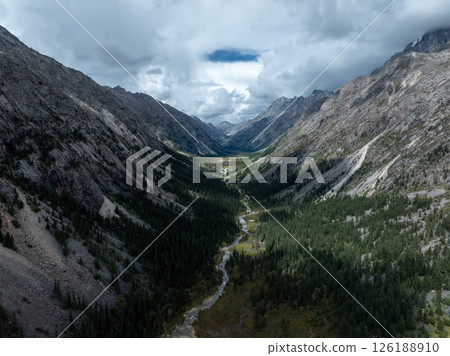 Aerial view of beautiful high altitude forest canyon and snow capped mountain landscape Aerial view of beautiful high altitude forest canyon and snow capped mountain landscape 126188910