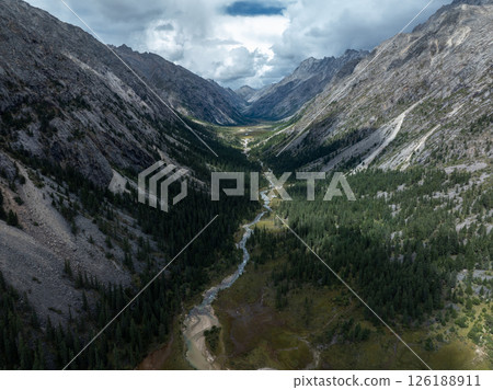 Aerial view of beautiful high altitude forest canyon and snow capped mountain landscape Aerial view of beautiful high altitude forest canyon and snow capped mountain landscape 126188911