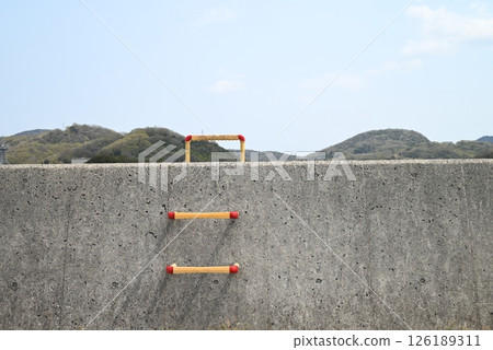 Embankment, blue sky and yellow ladder 126189311