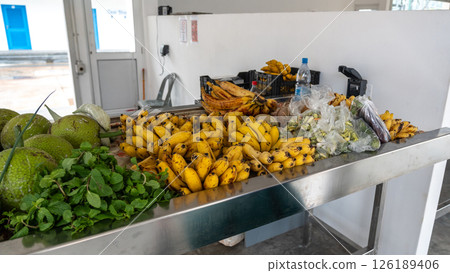 Fresh tropical fruits, bananas, breadfruit, and herbs on a local market table at Praslin, Seychelles Fresh tropical fruits, bananas, breadfruit, and herbs on a local market table at Praslin, Seychelles 126189406