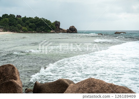 Coastal view of La Digue Island, Seychelles, with granite rocks, sandy beach, shoreline vegetation Coastal view of La Digue Island, Seychelles, with granite rocks, sandy beach, shoreline vegetation 126189409