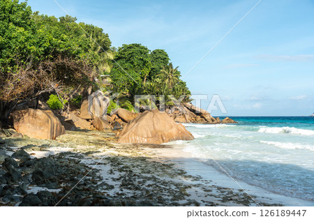 Picturesque Anse Patates beach during low season with granite boulders, tropical coastline, waves Picturesque Anse Patates beach during low season with granite boulders, tropical coastline, waves 126189447