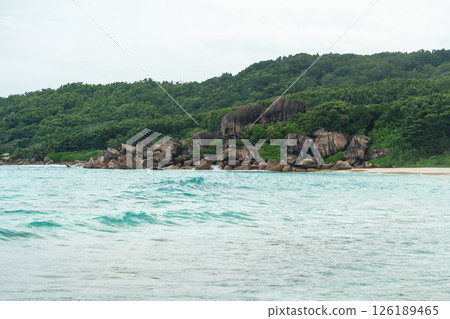 A typical Seychelles coast features granite boulders, dense tropical vegetation A typical Seychelles coast features granite boulders, dense tropical vegetation 126189465