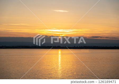 Sunset over the ocean, with the sun low on the horizon, contrast between sky and sea 126189471