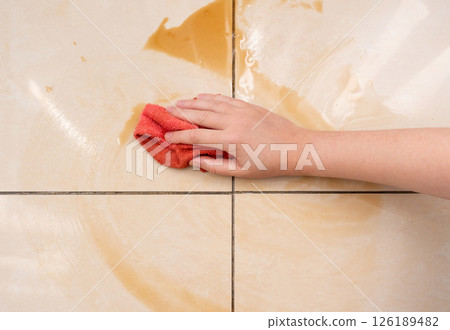 Spilled coffee, coffe puddle stain on tiled floor, messy leak with fallen cup, brown drink spillage Spilled coffee, coffe puddle stain on tiled floor, messy leak with fallen cup, brown drink spillage 126189482