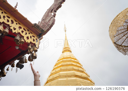 woman hand touch to small bell in temple at chiangmai Thailand in summer season woman hand touch to small bell in temple at chiangmai Thailand in summer season 126190376