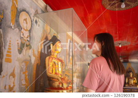 asian woman travel and see to gold buddha statue at chiangmai  Thailand in summer season 126190378