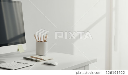 Minimalist workspace enhances morning focus, sunlight casts shadows, aiding focus 126191622