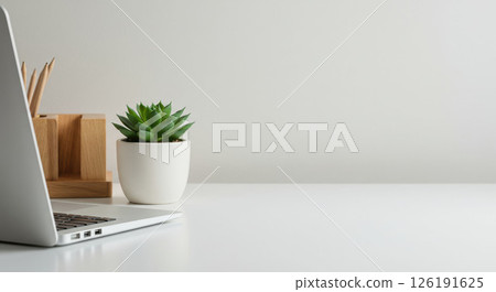 Minimalist desk with laptop, plant creating clean workspace, very clean setup 126191625