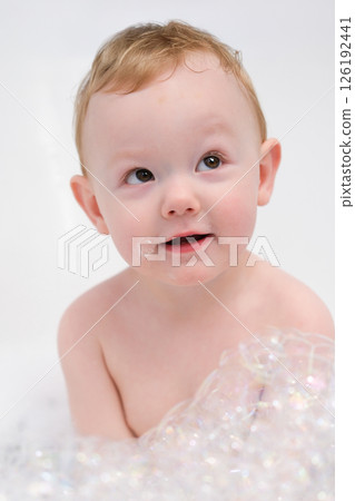Little boy playing in a bathtub with soap suds 126192441