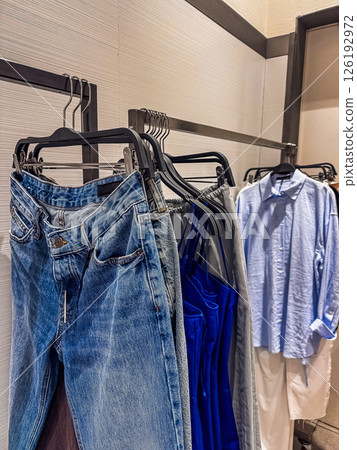 Hanging denim jeans and vibrant clothing in a contemporary retail space showcasing fashion. High quality photo 126192972