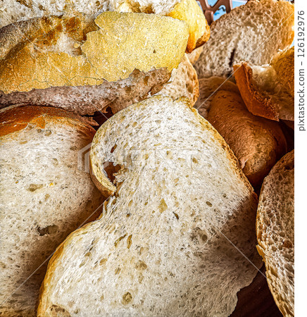 Close-up of assorted bread slices showcasing textures and crusts in a woven basket. High quality photo 126192976