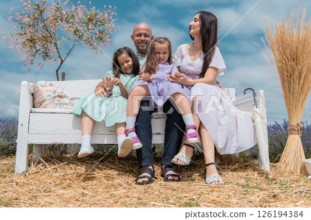 A nicely dressed family in a lavender field. A young family in a lavender field. A nicely dressed family in a lavender field. A young family in a lavender field. 126194384