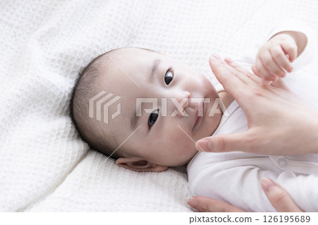 Mom's hands applying cream to baby Mom's hands applying cream to baby 126195689