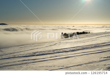 Winter landscape, a ski track in the snow, mountains of the Wasserkuppe. Wasserkuppe, in Hesse, Germany. Traveling to the mountains in the winter. Winter landscape, a ski track in the snow, mountains of the Wasserkuppe. Wasserkuppe, in Hesse, Germany. Traveling to the mountains in the winter. 126195714