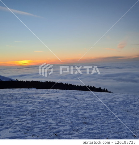 Winter sunset landscape, a ski track in the snow, mountains of the Wasserkuppe. Wasserkuppe, in Hesse, Germany. Traveling to the mountains in the winter. 126195723