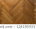 Hardwood oak parquet floor of herringbone flooring, top view. 126195933