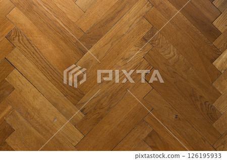 Hardwood oak parquet floor of herringbone flooring, top view. 126195933